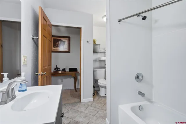 a bathroom with a tub a sink and a large mirror