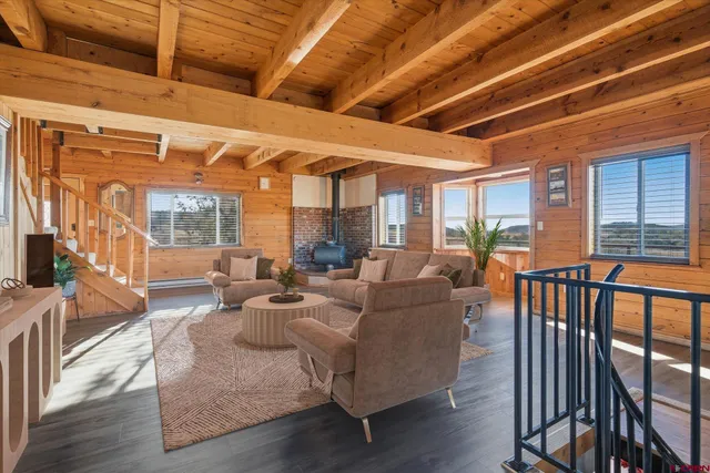 a living room with furniture wooden floor and a large window