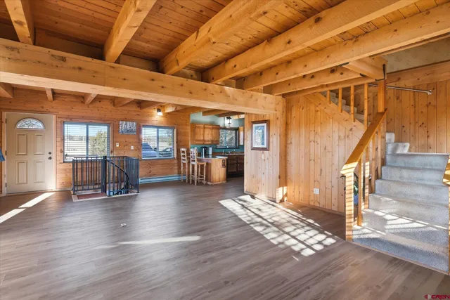a view of an entryway with wooden floors and stairs