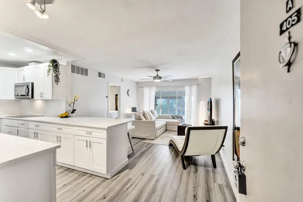 a large white kitchen with a window and stainless steel appliances