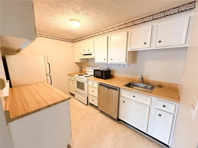 a kitchen with cabinets appliances a sink and a counter top space