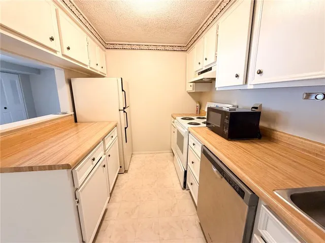 a kitchen with a sink a stove and cabinets