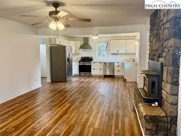 a view of a livingroom with furniture a ceiling fan and wooden floor