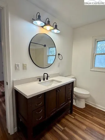 a bathroom with a toilet sink vanity and mirror
