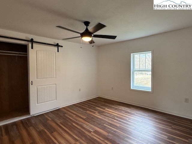304 Elk River Road Elk Park, NC 28622 - Photo 19 of 36 an empty room with wooden floor ceiling fan and windows