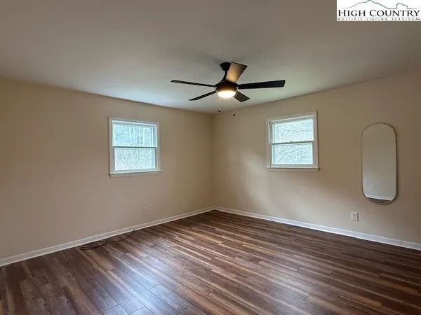 a view of a room with wooden floor and a window