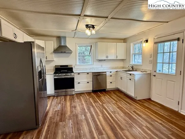 a kitchen with stainless steel appliances a sink a stove a refrigerator and cabinets