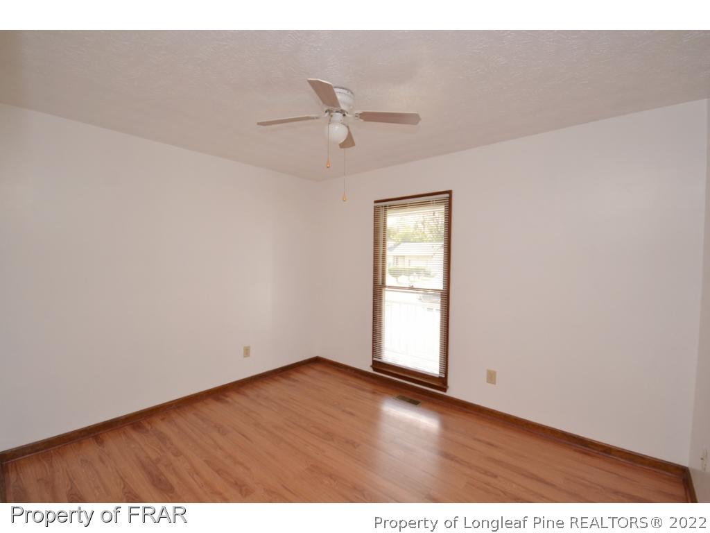 612 Jennings Farm Road Fayetteville, NC 28314 - Photo 11 of 27 an empty room with wooden floor ceiling fan and windows