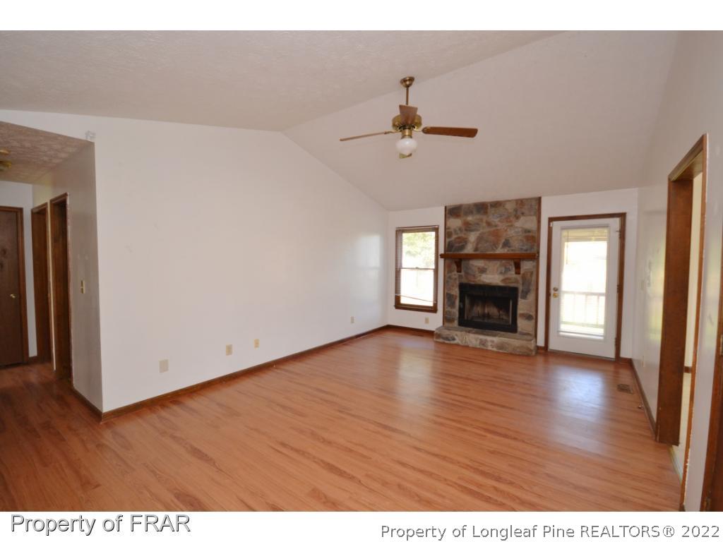 612 Jennings Farm Road Fayetteville, NC 28314 - Photo 2 of 27 a view of empty room with wooden floor and fireplace