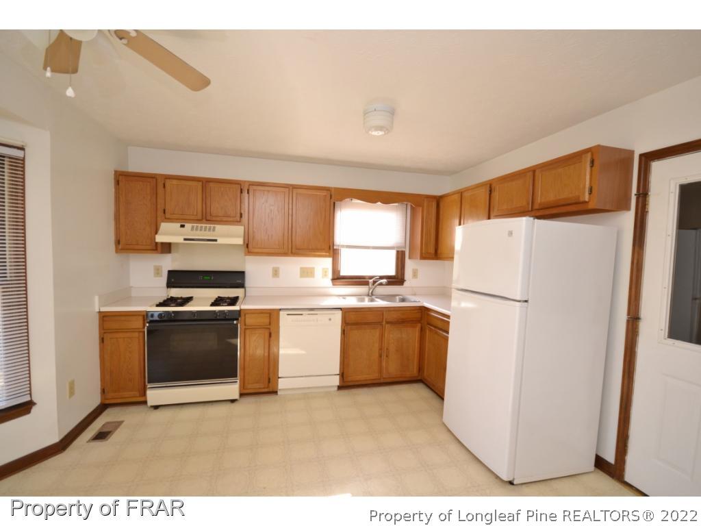 612 Jennings Farm Road Fayetteville, NC 28314 - Photo 7 of 27 a kitchen with a refrigerator and a stove