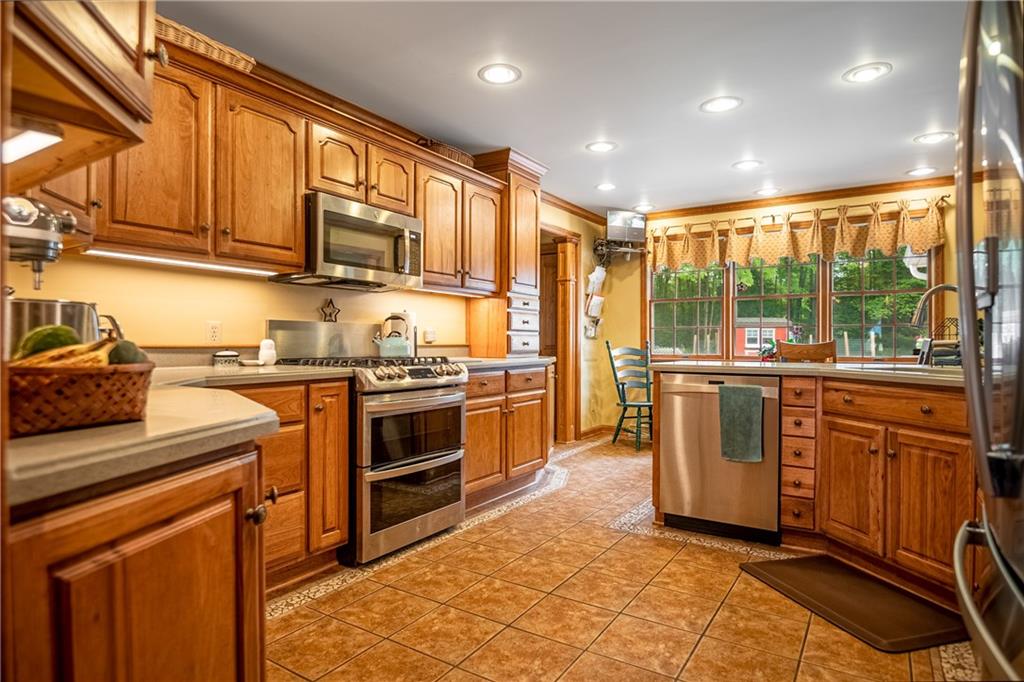 289 Nutt Road Grove City, PA 16127 - Photo 14 of 25 a kitchen with stainless steel appliances granite countertop a stove a sink and a refrigerator