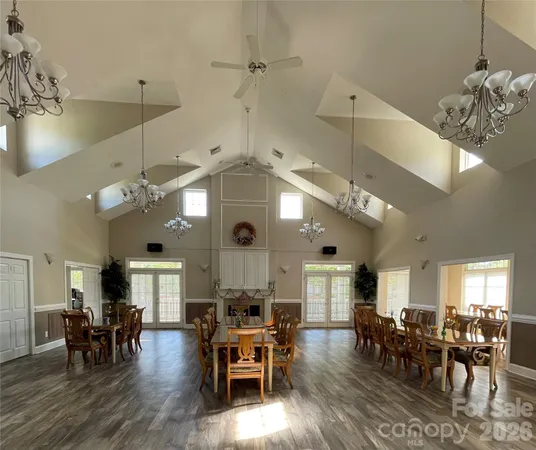 an open kitchen with dining table wooden floor and appliances