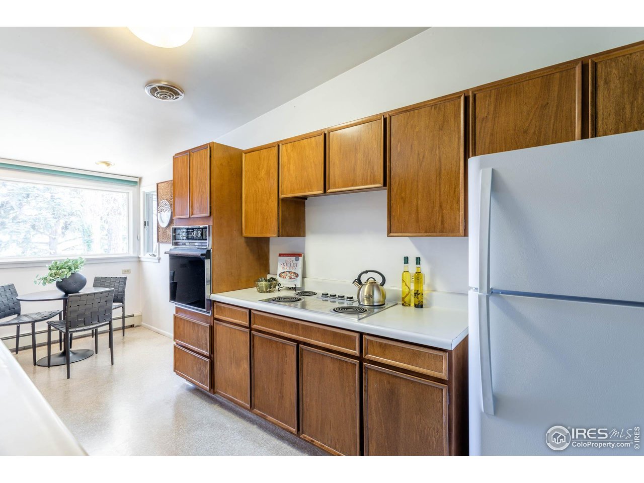 2207 Bluebell Avenue Boulder, CO 80302 - Photo 16 of 47 a kitchen with a refrigerator a stove a sink dishwasher and a dining table with wooden floor