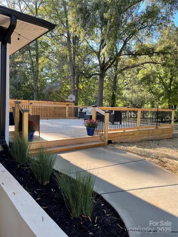 a view of a patio with table and chairs potted plants and large tree