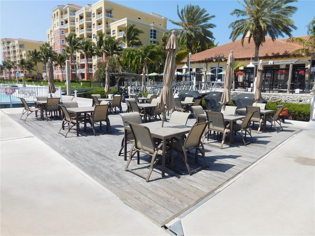 102 Riviera Dunes Way, Unit S7 Palmetto, FL 34221 - Photo 26 of 56 a view of a patio with table and chairs potted plants and palm trees