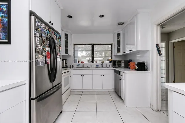 a kitchen with stainless steel appliances a refrigerator sink and cabinets