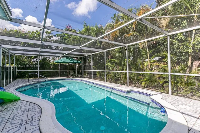 a view of a swimming pool with a patio and a yard