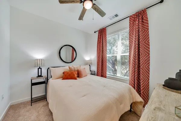 a bedroom with a large bed and a chandelier