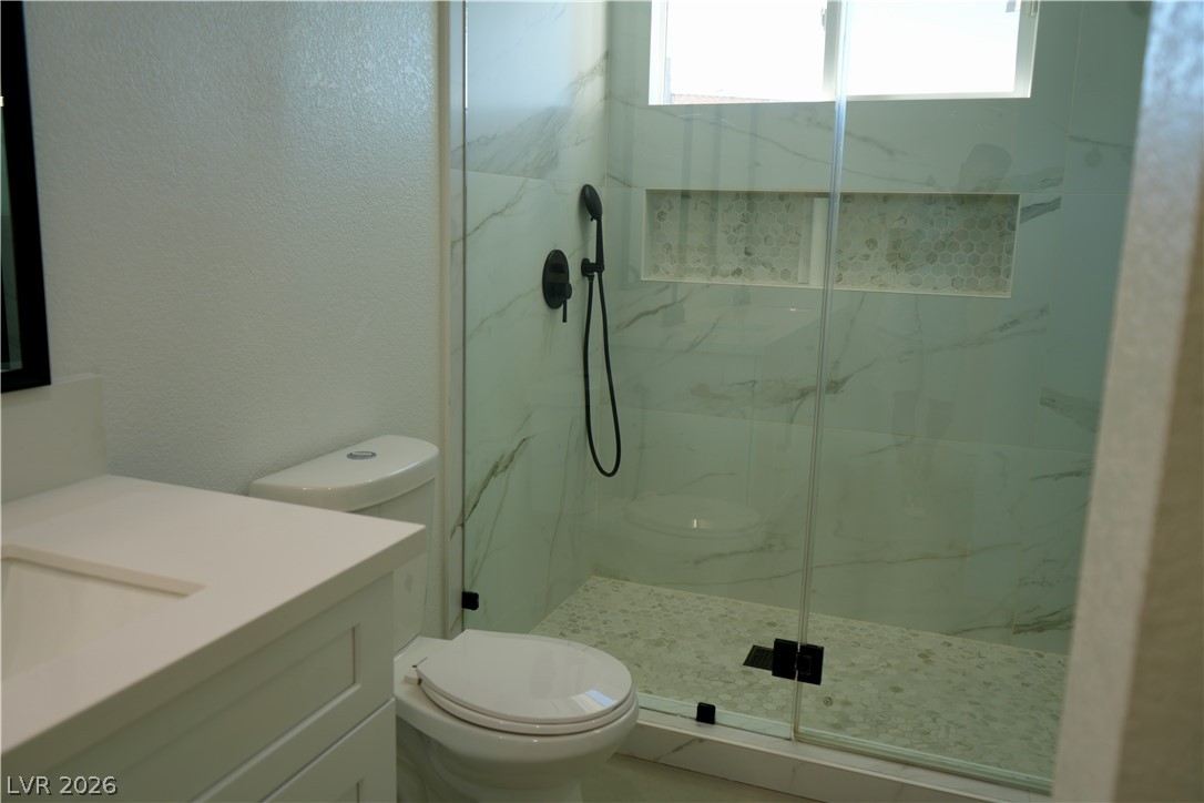 2351 Valleywood Road Henderson, NV 89014 - Photo 15 of 43 Bathroom with a textured wall, vanity, and a marble finish shower