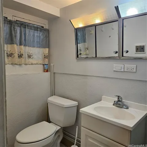 a bathroom with a sink a toilet and mirror
