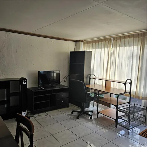 a view of a workspace with furniture and a window