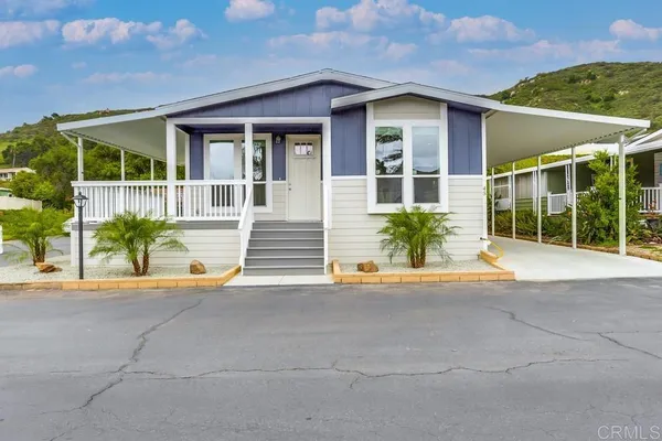 a front view of a house with a garden and plants