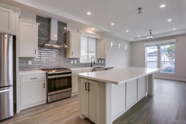 a kitchen with stainless steel appliances granite countertop a sink stove and refrigerator