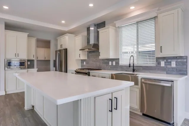 a kitchen with a sink a stove a refrigerator a center island and cabinets