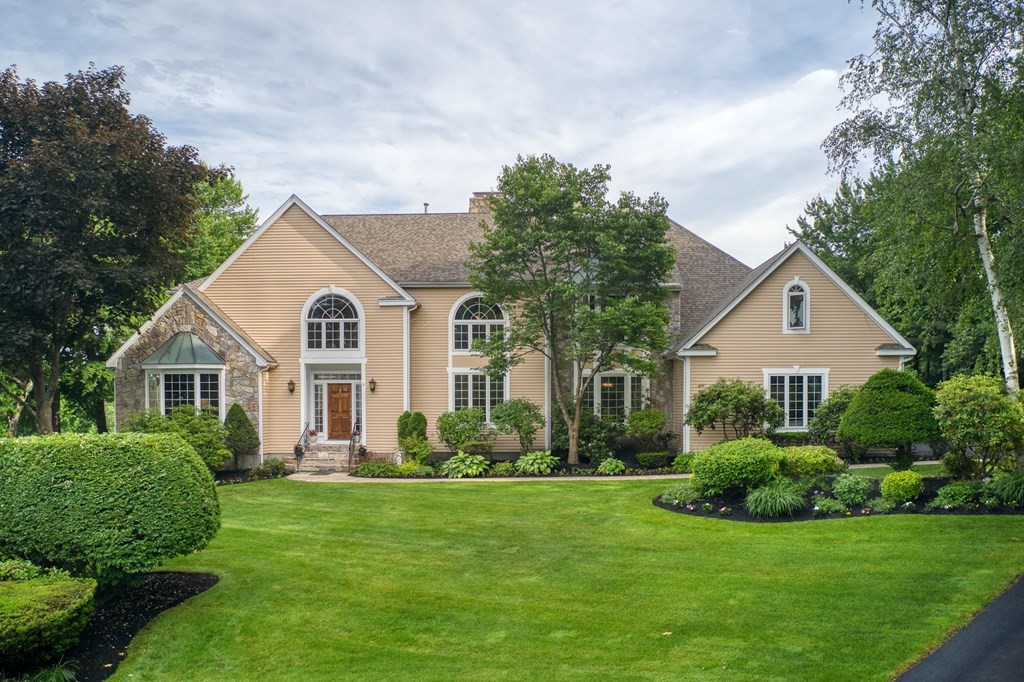 a front view of a house with a yard and green space