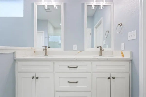 a bathroom with double vanity sink and mirror