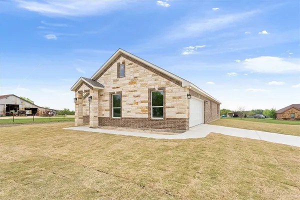a view of a house with a yard and road