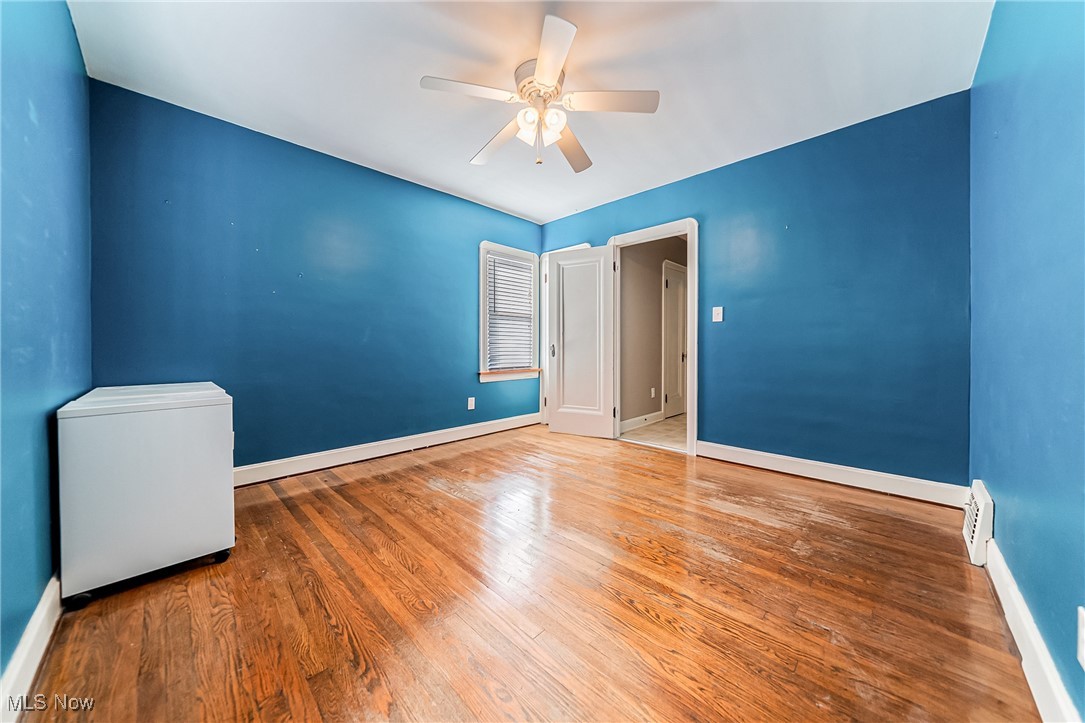 6711 Forest Avenue Parma, OH 44129 - Photo 18 of 33 Unfurnished room with wood finished floors, a ceiling fan, and a baseboard heating unit