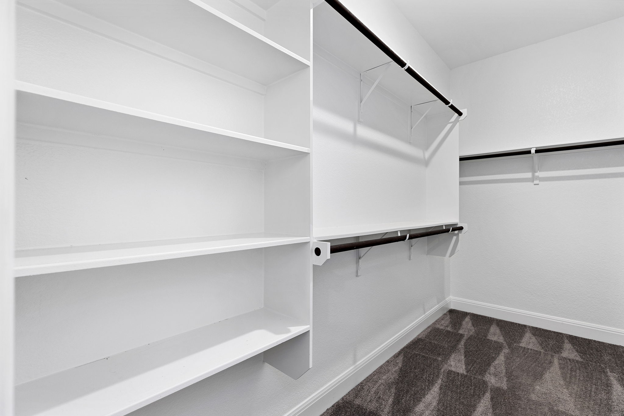 116 Raleigh Drive Georgetown, TX 78633 - Photo 14 of 28 Functional custom shelving and ample hanging rods provide versatile storage in this walk-in closet.