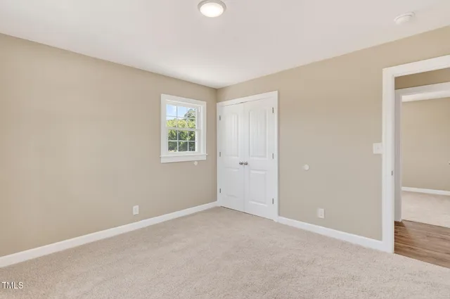 an empty room with windows and closet