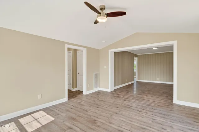 a view of an empty room with wooden floor