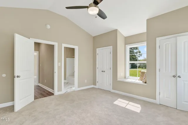 a view of an empty room with window and closet area