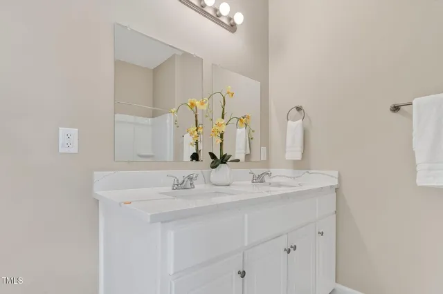a bathroom with a double vanity sink and a mirror