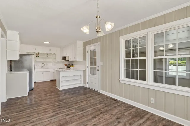 a large white kitchen with cabinets