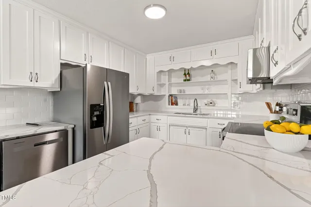 a kitchen with stainless steel appliances a refrigerator sink and stove