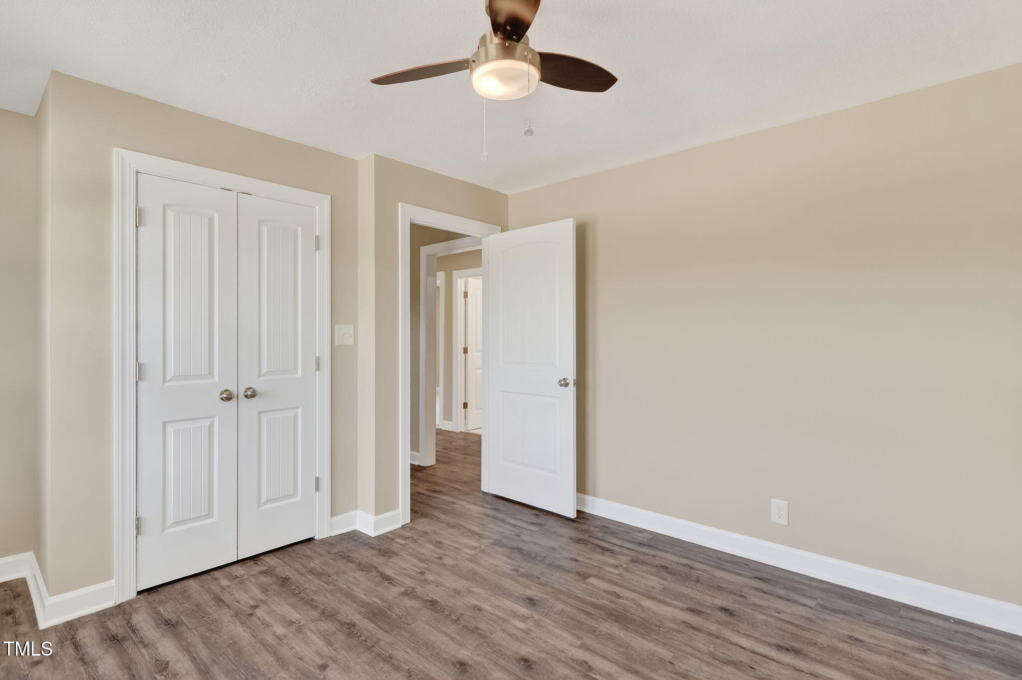 6715 Princeton Kenly Road Princeton, NC 27569 - Photo 9 of 35 an empty room with wooden floor a ceiling fan and windows