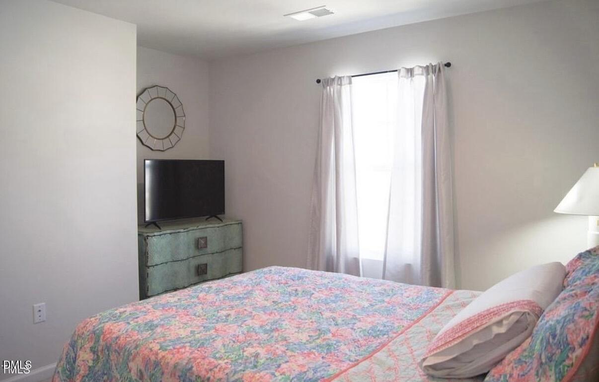 5006 Tura Street Raleigh, NC 27610 - Photo 27 of 32 a bedroom with a bed and a flat tv screen on dresser
