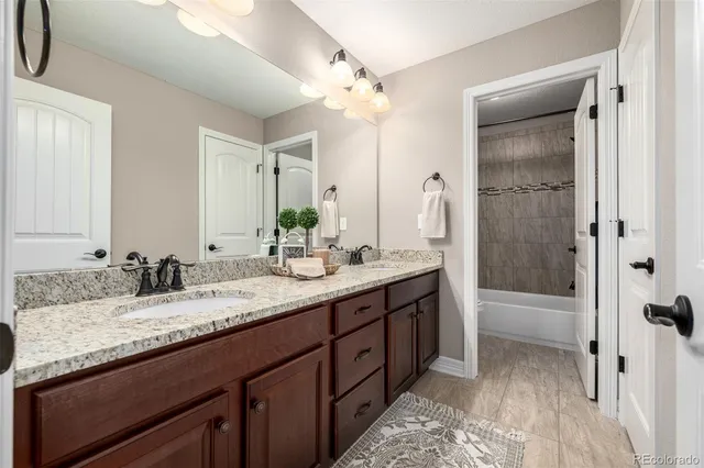 a bathroom with a granite countertop sink toilet and shower