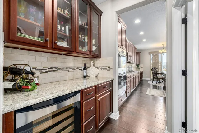 a kitchen with stainless steel appliances granite countertop a sink a stove and a wooden floors