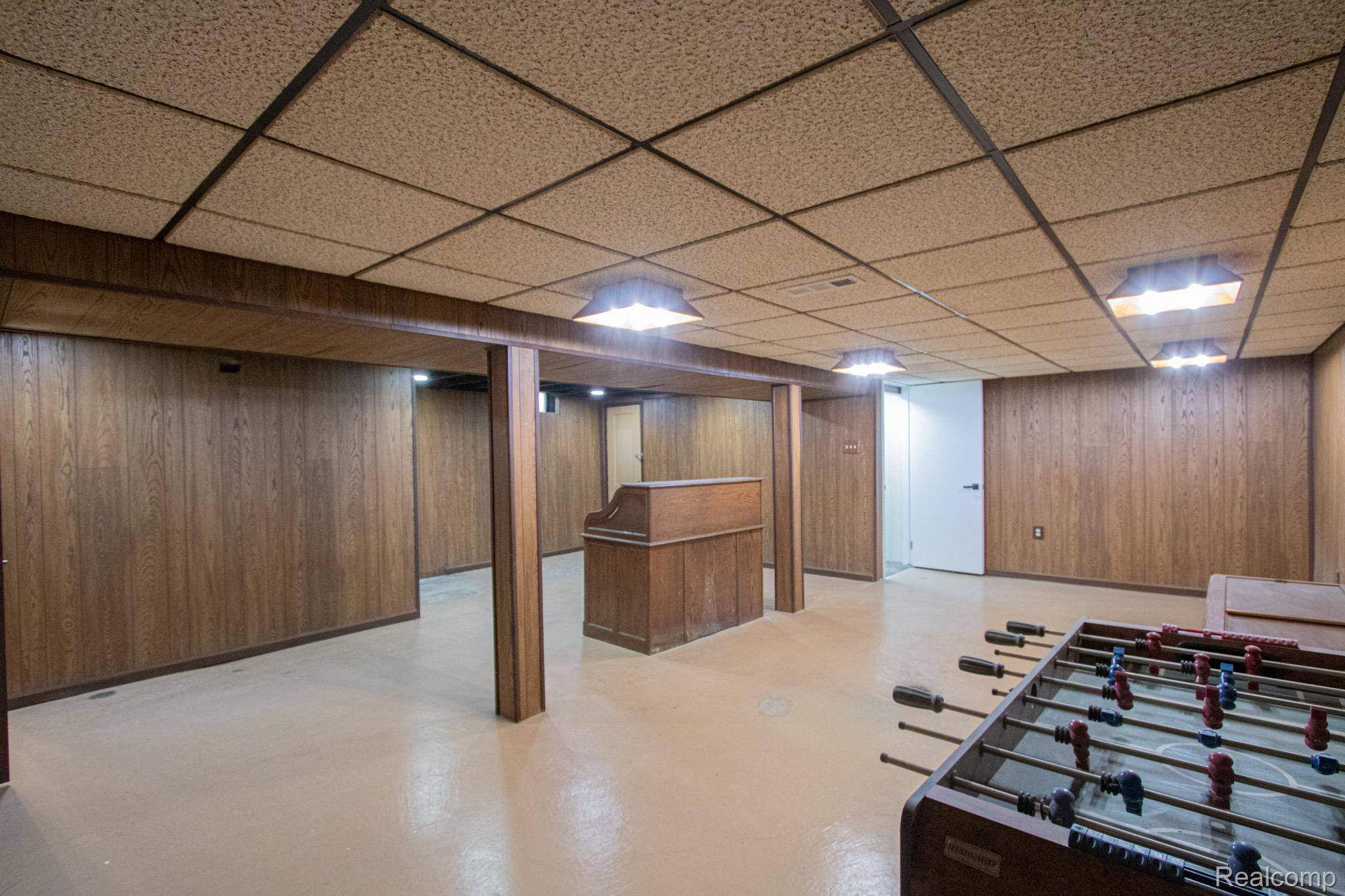 31000 Fall Fraser, MI 48026 - Photo 22 of 28 Rec room featuring wood walls, a drop ceiling, and finished concrete flooring