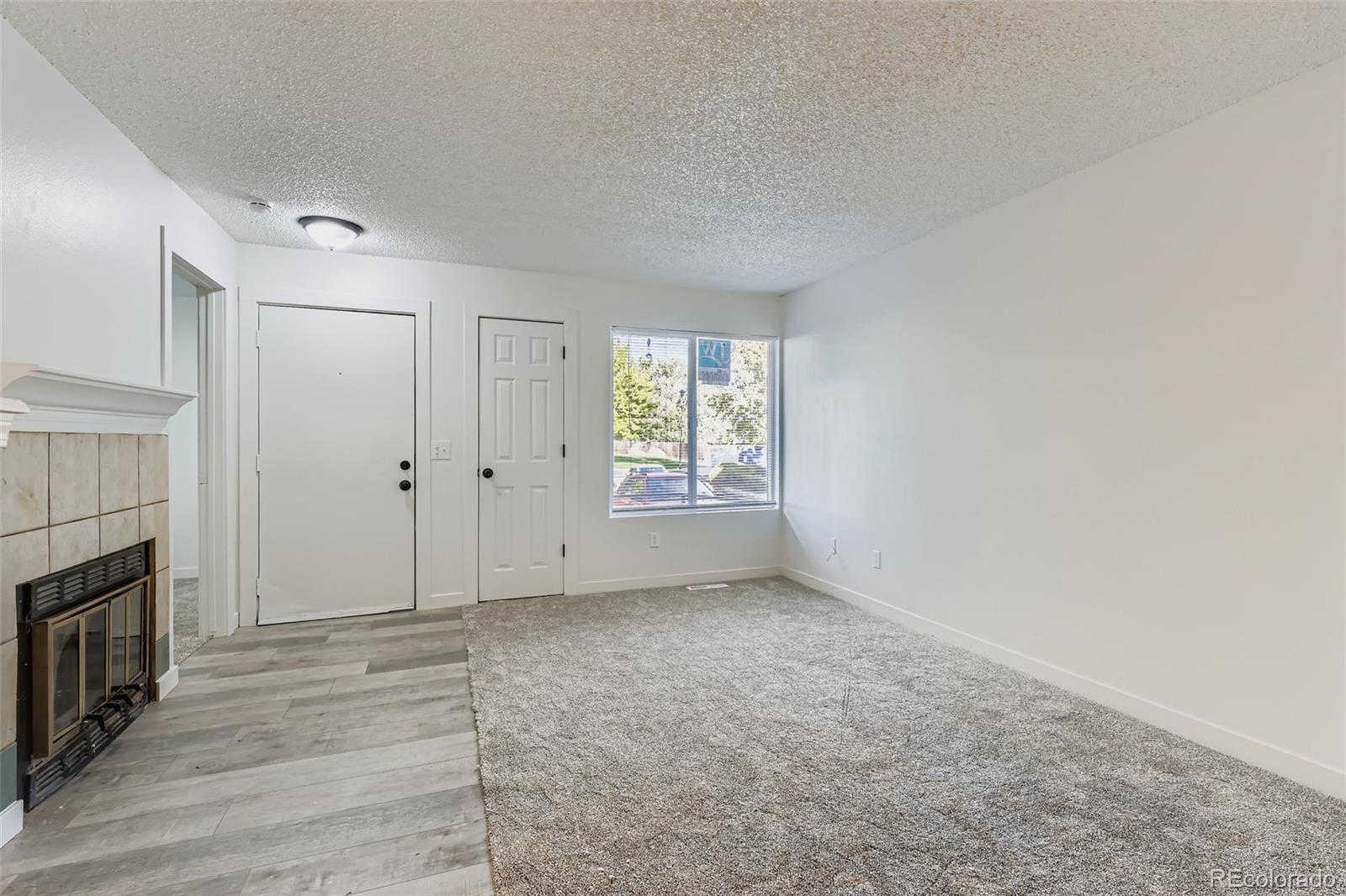 1845 Kendall Street, Unit 103A Denver, CO 80214 - Photo 2 of 11 a view of an empty room with wooden floor and a window