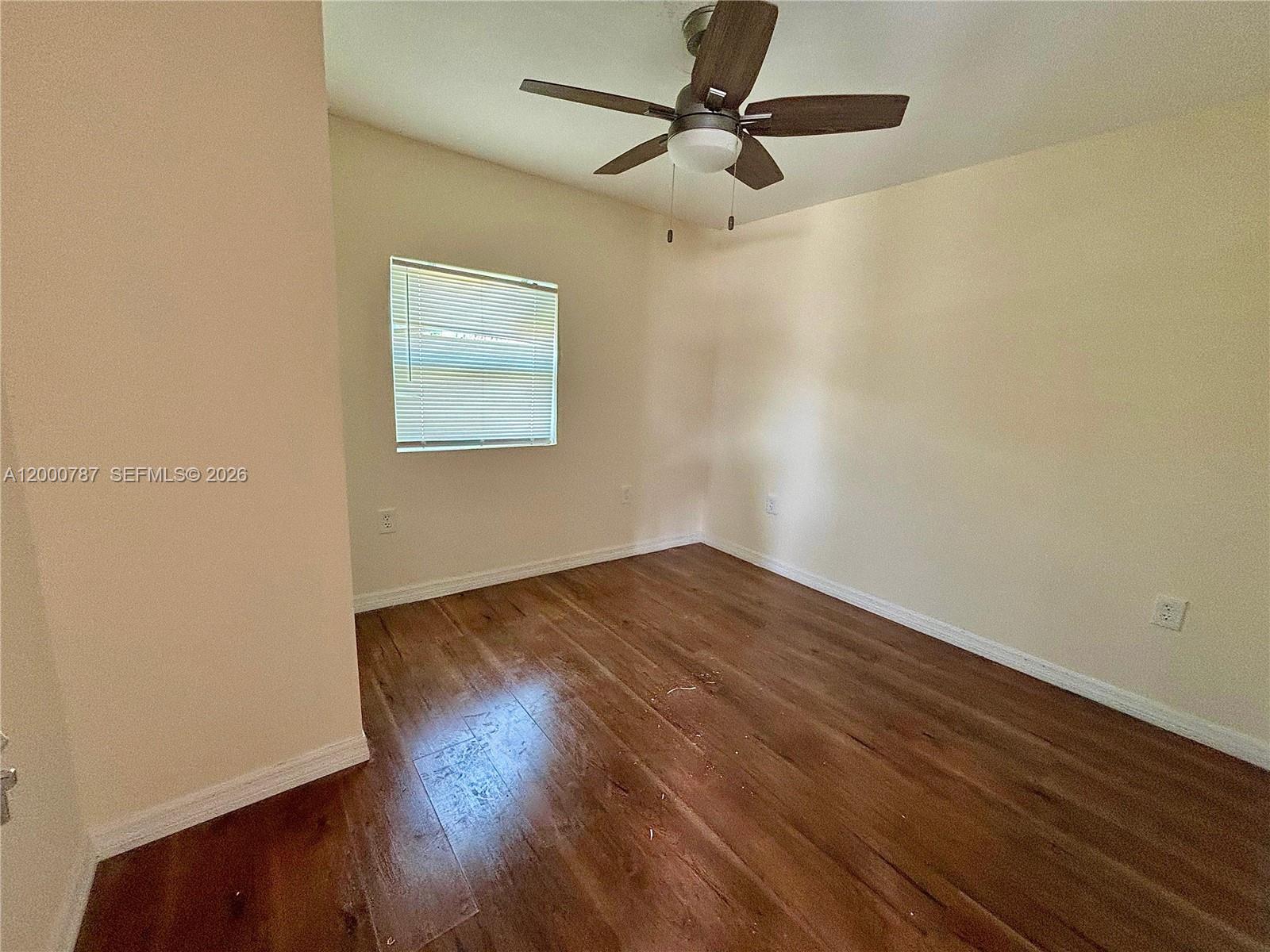 514 North 27th Street, Unit B Fort Pierce, FL 34947 - Photo 3 of 7 an empty room with wooden floor ceiling fan and windows