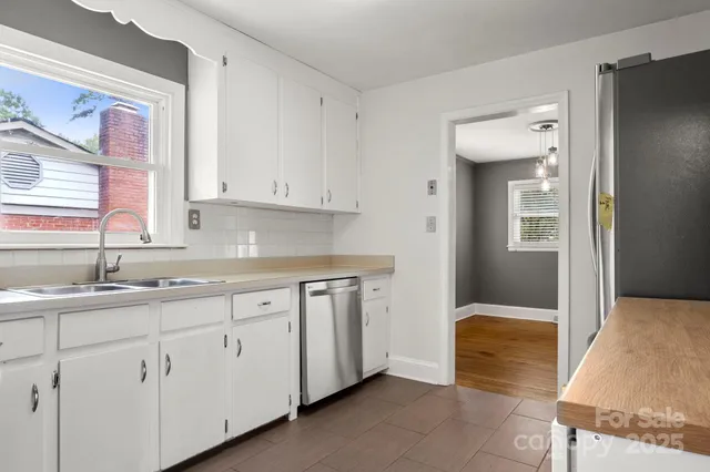 a kitchen with white cabinets and sink