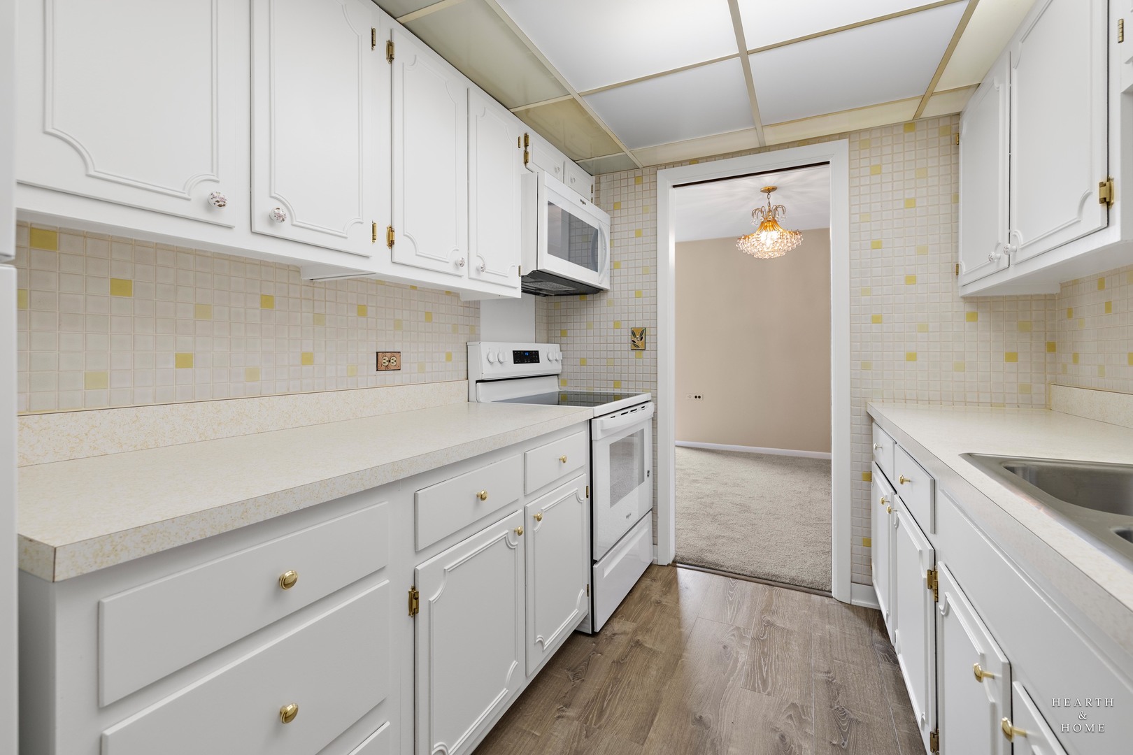 5300 Walnut Avenue, Unit 12B Downers Grove, IL 60515 - Photo 5 of 30 a kitchen with granite countertop white cabinets and white appliances