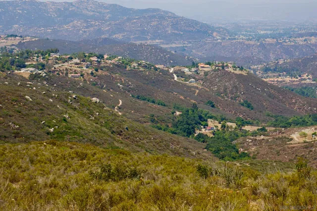 an aerial view of house with yard and mountain view in back