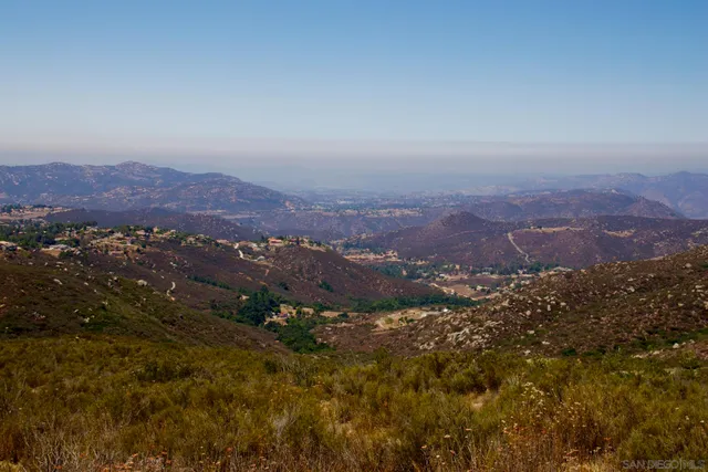 a view of a mountain range with lush green forest